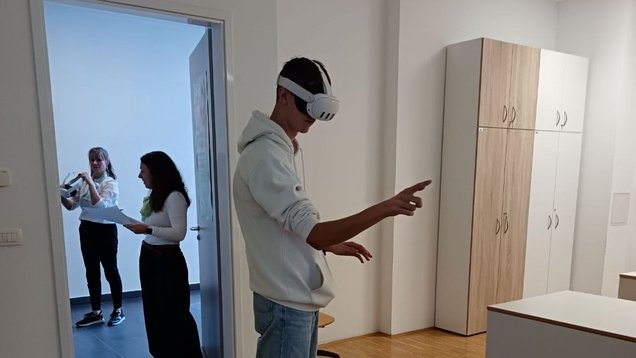 Obiskovalec z VR-očali raziskuje deficitarne poklice. Na zaposlitveno-kariernem sejmu Želim se zaposliti v Novi Gorici, 14. oktobra 2026, v organizaciji Območne službe Nova Gorica Zavoda Republike Slovenije za zaposlovanje. Lokacija: Medpodjetniški izobraževalni center.