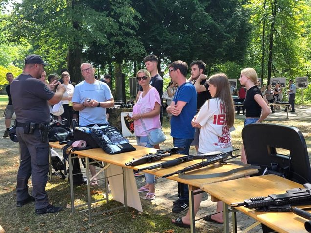 Obiskovalci si ogledujejo policijsko opremo na stojnicah, v okviru Dneva odprtih vrat Policijske akademije v Tacnu, Ljubljana, 6. avgusta 2026.