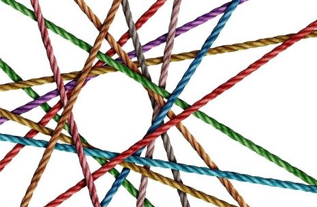 Simbolična slika. Raznobarvne vrvice (zelene, modre, rdeče, rumene, vijolične, sive) se križajo in prepletajo med seboj, tako da v sredini tvorijo obliko praznega kroga.