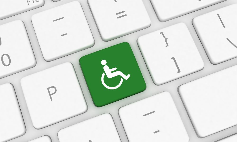 Dekorativna slika: svetlo siva tipkovnica z belimi tipkami, na sredini zelena tipka z belim znakom za invalida (človeška silhueta na invalidskem vozičku).